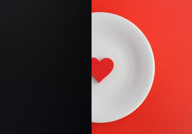 Collage Cuore rosso sul piatto bianco sullo sfondo nero e rosso Copia spazio Vista dall'alto