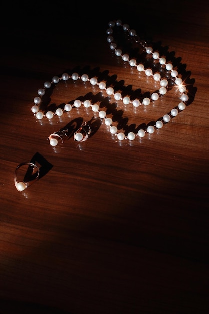 Collana di perle bianche su fondo di legno