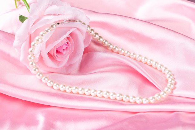 Collana di perle di bellezza su panno rosa