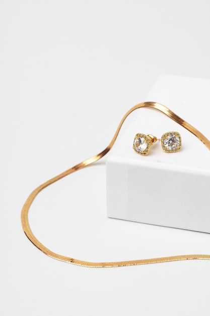 Collana e orecchini con diamanti dorati su sfondo bianco