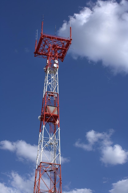 Collegamento della torre con l'albero e le antenne contro il cielo azzurro con nuvole Trasmissione e ricezione dei segnali