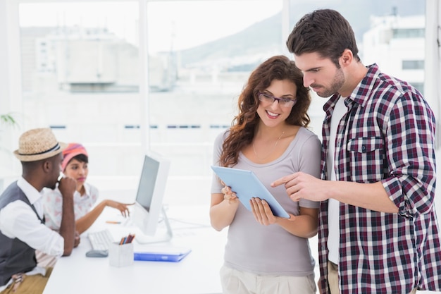 Colleghe in piedi e utilizzando tablet insieme