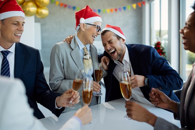 Colleghi allegri che si divertono mentre festeggiano la festa di Natale in ufficio