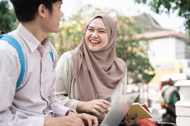 Colleghi asiatici dello studente che lavorano ad un computer portatile