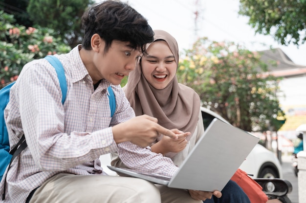 Colleghi asiatici dello studente che lavorano ad un computer portatile