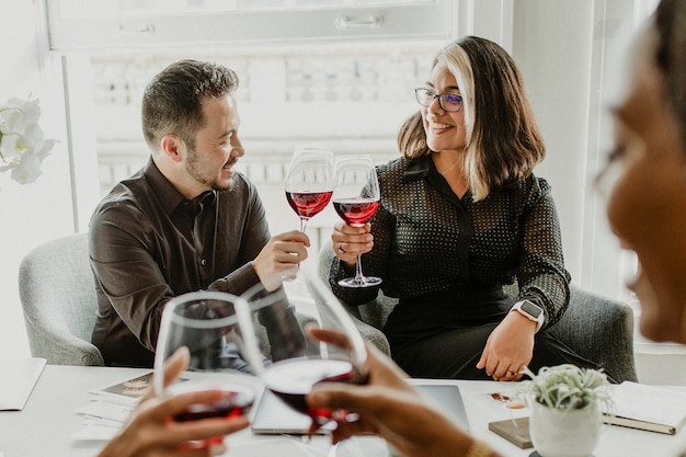 Colleghi che brindano bicchieri di vino al lavoro