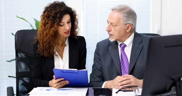 Colleghi che discutono i documenti finanziari in un ufficio