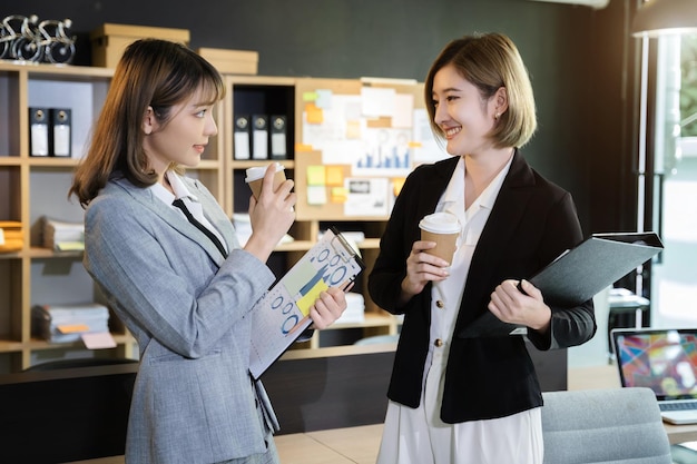 Colleghi che tintinnano tazze di caffè in ufficio