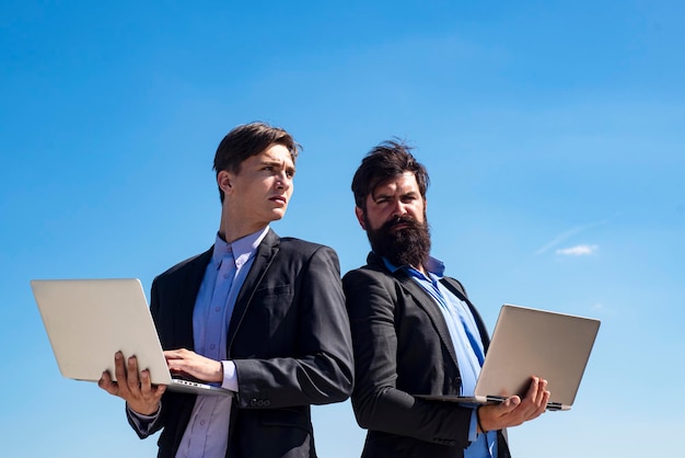 Colleghi. Concetto di lavoro di squadra di affari. Squadra con il computer portatile. Uomini d'affari. Uomo d'affari che lavora insieme.