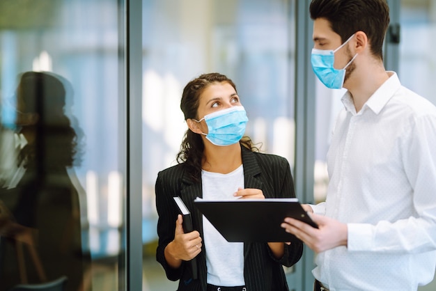 Colleghi di lavoro che indossano una maschera medica