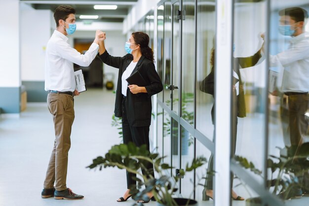 Colleghi di lavoro che urtano i gomiti mentre si salutano al lavoro.