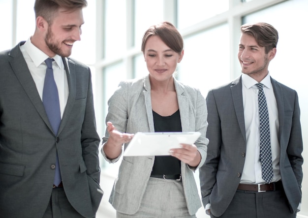 Colleghi di lavoro con una tavoletta digitale in piedi in ufficio