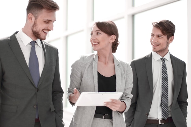 Colleghi di lavoro con una tavoletta digitale in piedi in ufficio