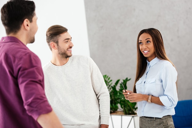 Colleghi di lavoro multietnici sorridenti che conversano in ufficio