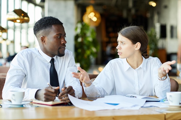 Colleghi di lavoro perplessi che lavorano con le carte