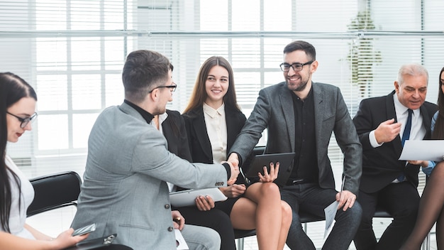 Colleghi di lavoro si stringono la mano a una riunione in ufficio. concetto di cooperazione