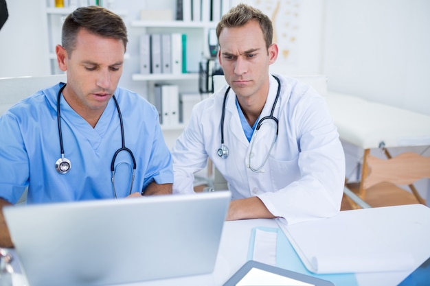 Colleghi medici concentrati che lavorano con il computer portatile