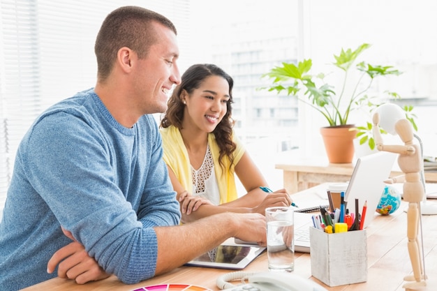 Colleghi sorridenti che collaborano con il computer portatile