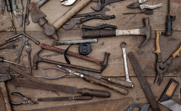 Collezione di antichi utensili manuali per la lavorazione del legno su un banco da lavoro ruvido in legno vecchio