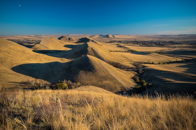 Colline dorate del paesaggio, piccole montagne contro il cielo blu