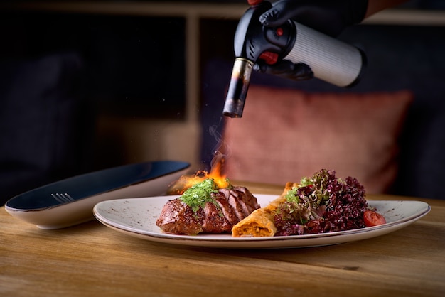 Collo di maiale con involtino di ceci e mix di insalata. Piatto principale del ristorante con carne, vitello o bistecca di manzo ben cotta