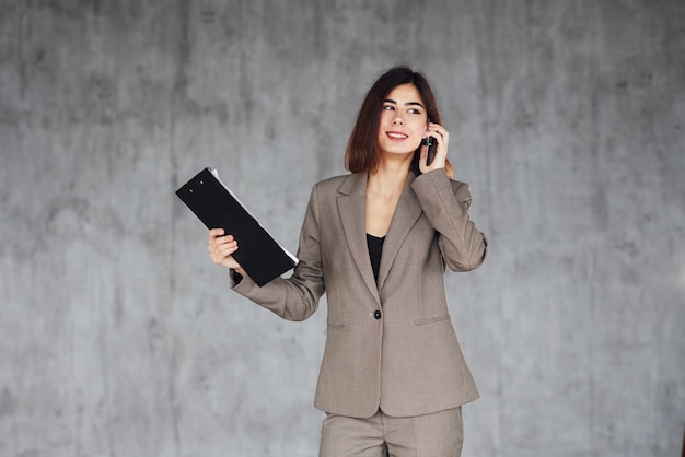 Colloqui per telefono Giovane donna in abiti formali è al chiuso Concezione di stile