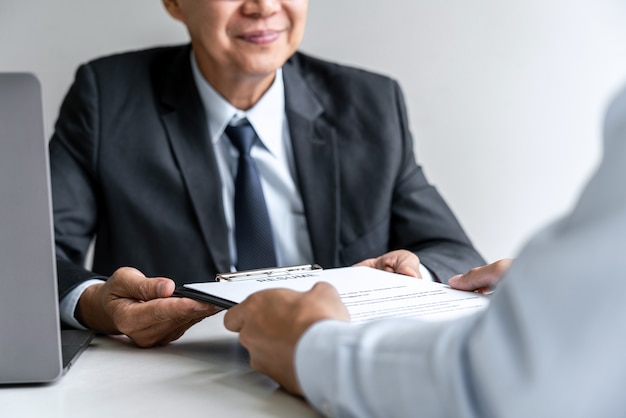 Colloquio del datore di lavoro per chiedere il candidato maschio per l'assunzione che parla nell'ufficio