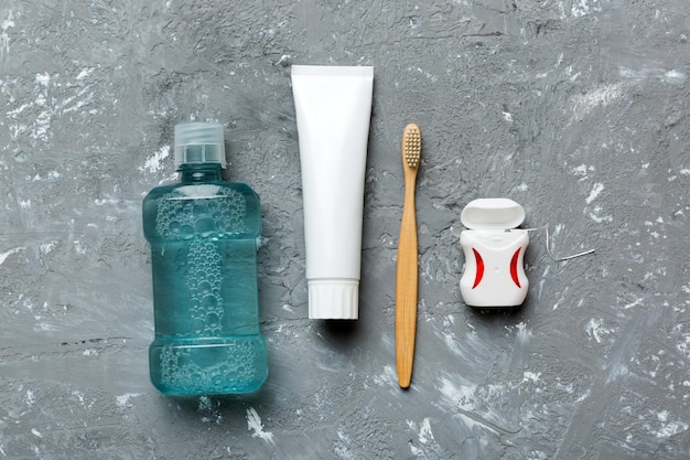 Collutorio e altri prodotti per l'igiene orale su tavolo colorato con spazio per la copia Igiene dentale piatta Prodotti per l'igiene orale e spazio per il testo su sfondo chiaro