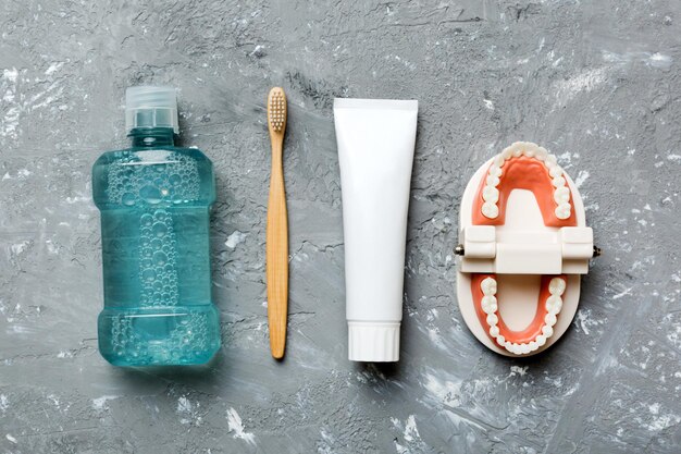 Collutorio e altri prodotti per l'igiene orale su tavolo colorato con spazio per la copia Posa piatta Igiene dentale Kit per l'igiene orale Concetto di dentista