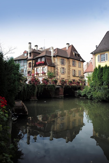 COLMAR FRANCIA 18 settembre 2015 Vista pittoresca sul canale con le tradizionali case a graticcio francesi e il ponte con i fiori nella foto verticale di Colmar