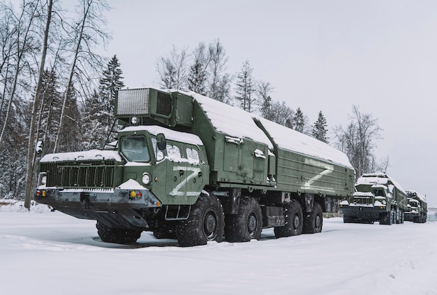 Colonna di equipaggiamento militare pesante delle forze armate russe sullo sfondo della foresta invernale Simbolo Z su veicoli militari Illustrazione di operazioni militari Il concetto di guerra in Europa