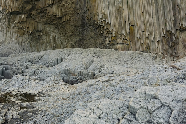 Colonnare di roccia basaltica Cape Stolbchaty sull'isola di Kunashir in primo piano basi di colonne di basalto lavico formano una specie di pavimentazione