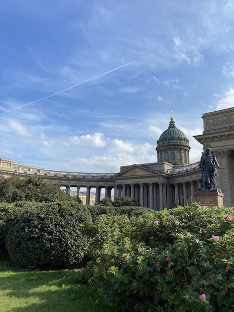 Colonne della cattedrale di Kazan contro il cielo blu in primo piano che sbocciano fiori e foglie verdi