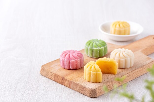 Colorata pelle di neve luna torta dolce mooncake nevoso tradizionale dessert salato per MidAutumn Festival su sfondo di legno luminoso primo piano stile di vita