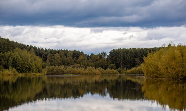 Colorate riflessioni albero fogliame nella calma acqua di stagno in una bella giornata autunnale. Un posto tranquillo e bellissimo per rilassarsi.