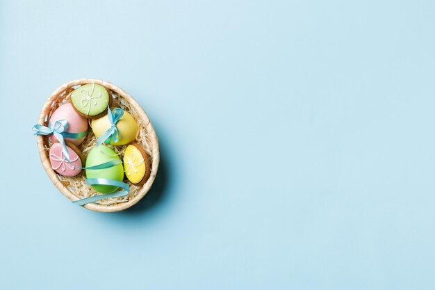 Colorati biscotti pasquali nel carrello con più colori Uova di Pasqua su sfondo colorato Colore pastello Uova di Pasqua Concetto di vacanza con spazio per la copia