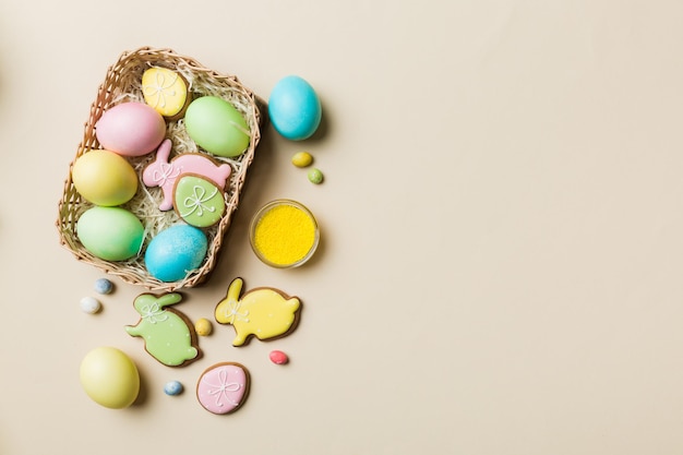 Colorati biscotti pasquali nel carrello con più colori Uova di Pasqua su sfondo colorato Colore pastello Uova di Pasqua Concetto di vacanza con spazio per la copia