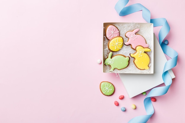 Colorati biscotti pasquali nel carrello con più colori Uova di Pasqua su sfondo colorato Colore pastello Uova di Pasqua Concetto di vacanza con spazio per la copia