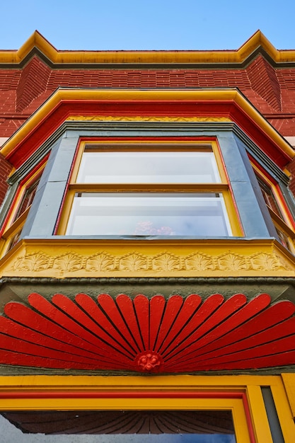 Colorati rivestimenti vittoriani di finestre e dettagli della facciata contro il cielo blu