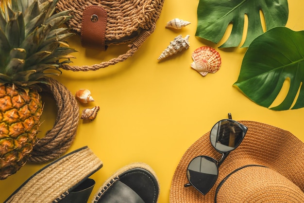 Colorato estate moda femminile outfit piatto lay Cappello di paglia scarpe di vimini ananas su sfondo giallo vista dall'alto ampia composizione Concetto di vacanza di moda estiva