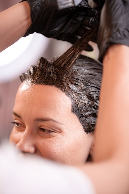 Colorazione dei capelli nel salone, acconciatura. Il mago professionista dipinge i capelli nel salone. Concetto di bellezza, cura dei capelli.