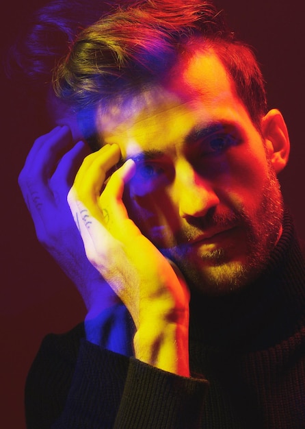 Colore a doppia esposizione e ritratto di un uomo con sovrapposizione isolato su uno sfondo scuro in studio Design della trama e volto di un uomo con creatività artistica colorata e persona futuristica su uno sfondo