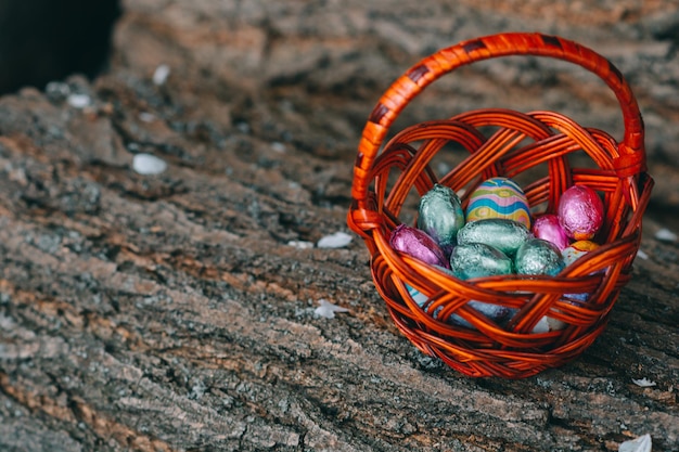 Colore pastello Pasqua uova di cioccolato in un cestino sfondo verde vintage profondità di campo ridotta