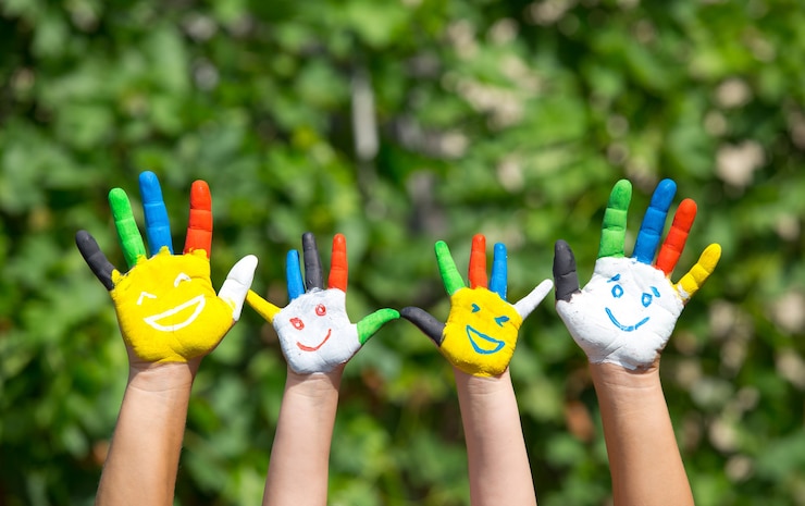 Colored hands with smile painted in colorful paints