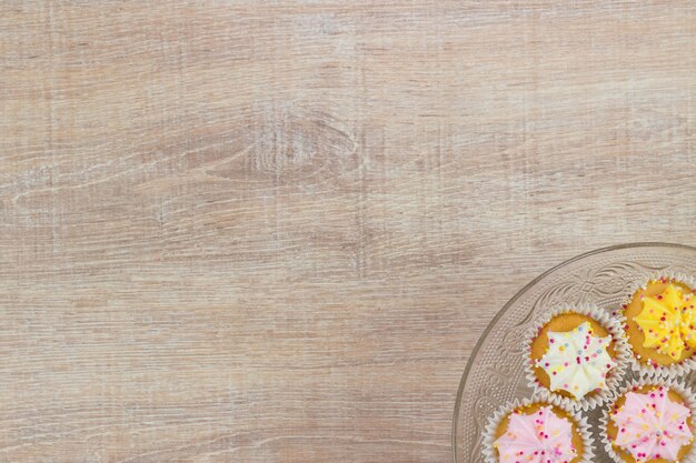 Colorful cupcakes su uno sfondo bianco di legno. Vista superiore con spazio per il testo.