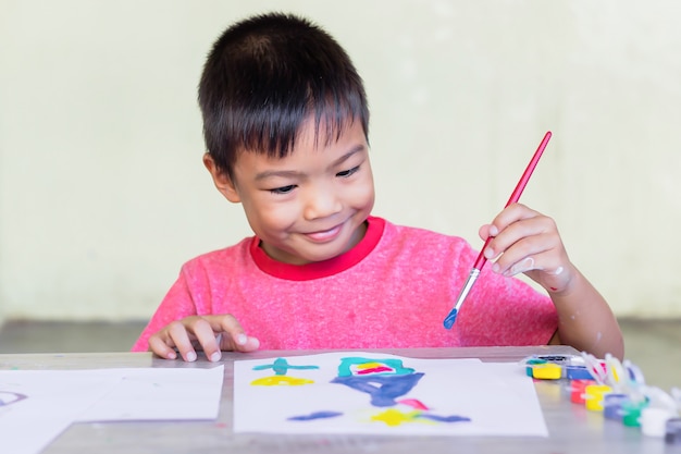 Colori asiatici del disegno e della pittura dello studente sulla carta nella stanza.