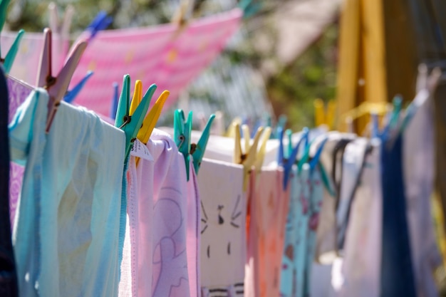 Colori i vestiti che appendono in linea in giardino