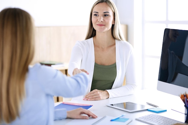 Colpo alla testa della donna d'affari. Uomini d'affari o colleghi che discutono di qualcosa durante la riunione seduti alla scrivania in ufficio. Stile di abbigliamento casual. Concetto di audit, tasse o avvocato.