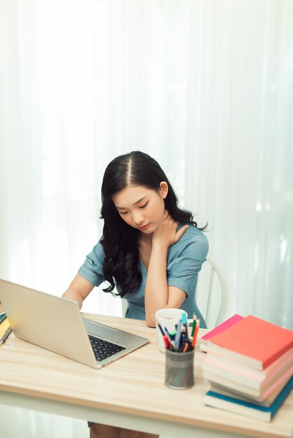 Colpo alla testa giovane donna stressata che soffre di dolore al collo, sensazione di stanchezza della giornata lavorativa di sovraccarico.