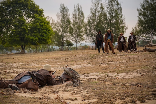 Colpo d'azione vintage di un gruppo di cowboy nel prato mattutino